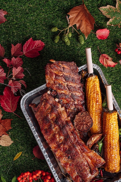 Autumn bbq grilled pork ribs corn and grilled peppers baked garlic autumn grill party concept Thanksgiving Day autumn harvest