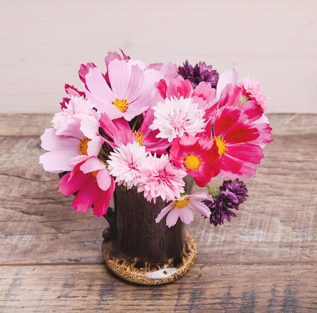 Autumn Bouquet of flowers in red shades of purple pink Cosmos cornflowers kosmeja Flower composition on wooden desk background