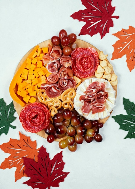 Autumn charcuterie board with cheese and meat snacks grapes and crackers