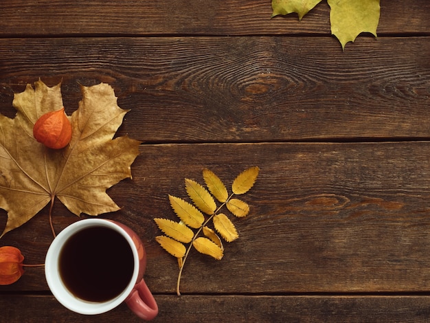 Autumn coffee or tea warm leaves wooden surface wall concept. Seasonal coziness. Disease prevention