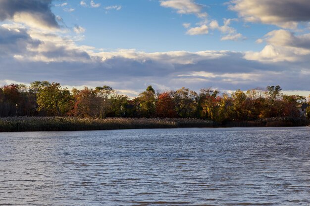 Autumn colored water view of sunset autumn picturesque nature with autumn river and yellowed autumn trees in the autumn sunset Water picturesque autumn landscape Soft filter applied