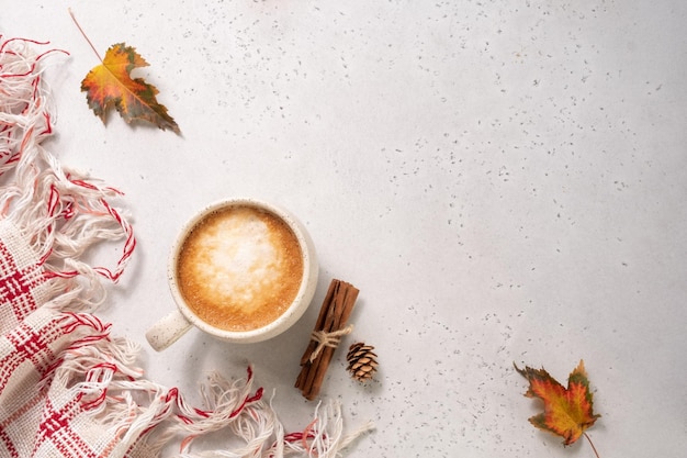 Autumn composition cup of coffee blanket autumn leaves cinnamon sticks on white background