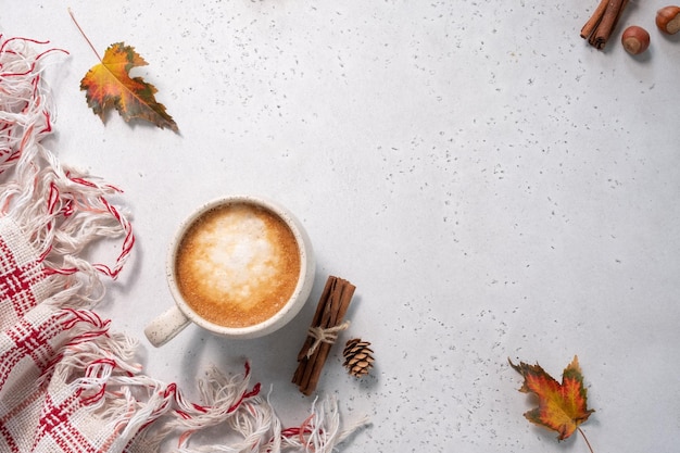 Autumn composition cup of coffee blanket autumn leaves cinnamon sticks on white background