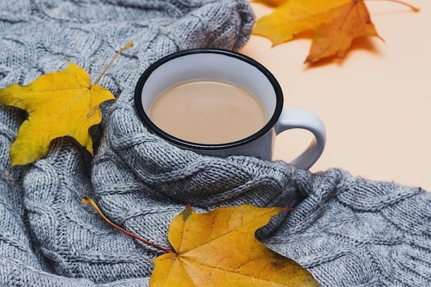 Autumn composition cup of coffee sweater yellow leaves