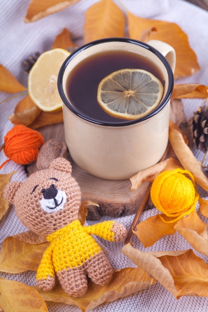 Autumn composition, cup of tea with lemon. Sunday relaxing and still life concept. Knitted toy, teddy, amigurumi. Handmade. DIY