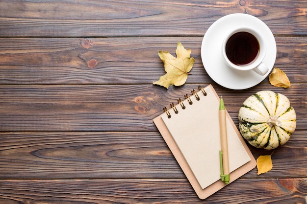 Autumn composition fallen leaves and craft sketchbook mock up on colored background Top view Flat lay with copy space