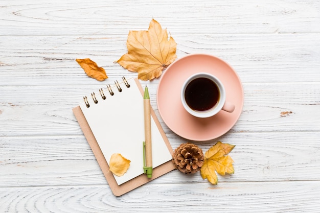 Autumn composition fallen leaves and craft sketchbook mock up on colored background Top view Flat lay with copy space