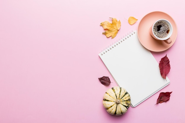 Autumn composition fallen leaves and notebook mock up on colored background Top view Flat lay with copy space