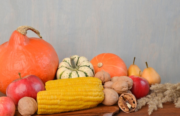 Autumn composition of vegetables and fruits on the table against the background of a light wall