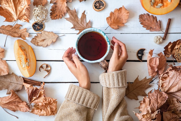 Autumn composition with leaves and a cup of tea, top view.