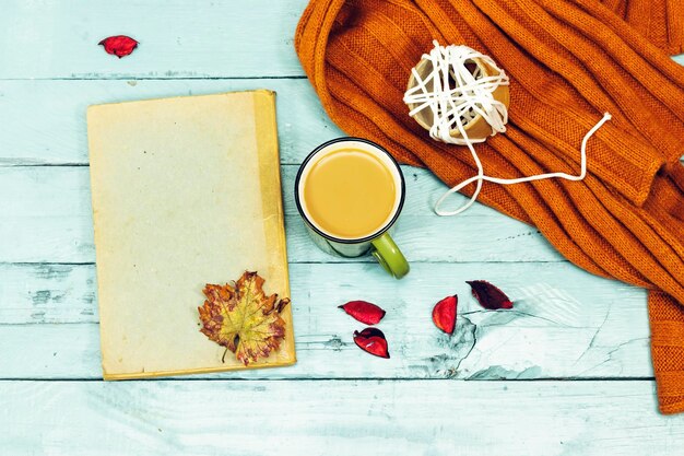 autumn concept old book with copy space cup of coffee and winter scarf