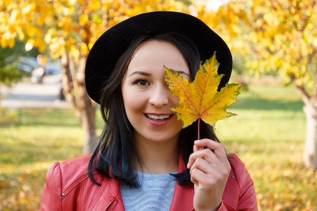 Autumn concept portrait of a girl woman in a hat and red jacket