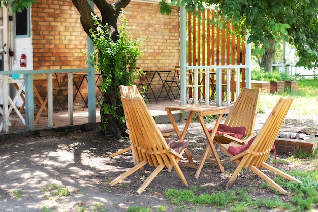 Autumn courtyard interior with garden furniture. Empty sun loungers and table on veranda of house