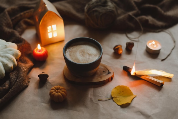 Autumn cozy home interior with a cup candles plaid Hygge home decor Halloween and Thanksgiving concept