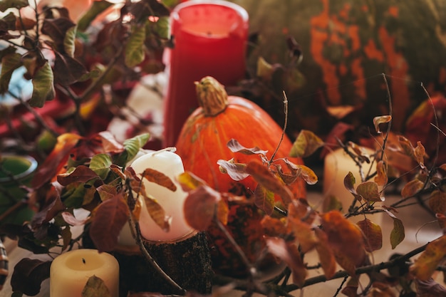 Autumn decor with pumpkin, candles and tableware