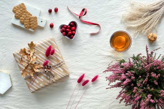 Autumn decorations  heather cranberry cookies tea and dry leaves