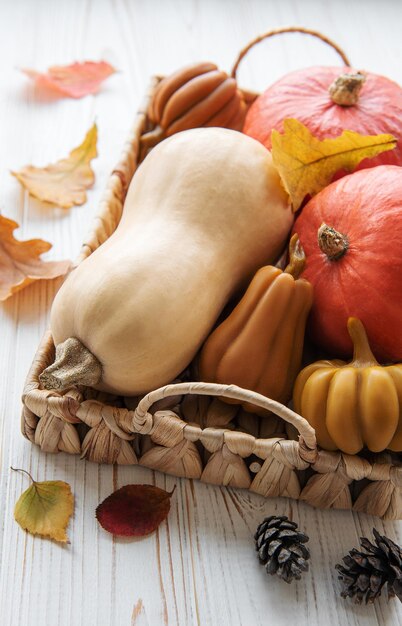 Autumn decorative pumpkins with fall leaves on wooden background