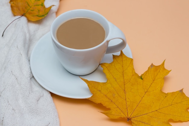 Autumn fall leaves a hot cup of coffee with milk white warm sweater