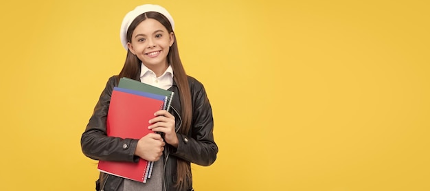 Autumn fall school Happy teenage girl back to school holding books yellow background education Portrait of schoolgirl student studio banner header School child face copyspace