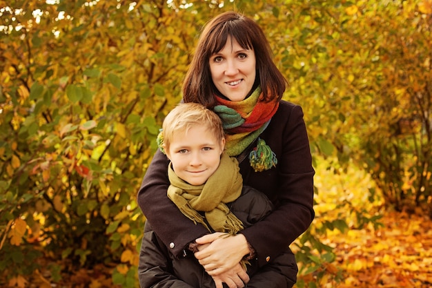 Autumn Family. Loving Mother and Son  in Fall Park Outdoors