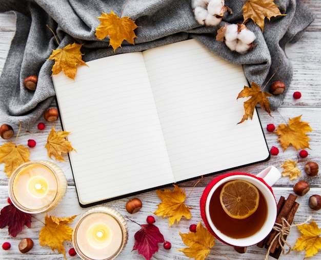 Autumn flat lay with notebook, cup of tea and leaves