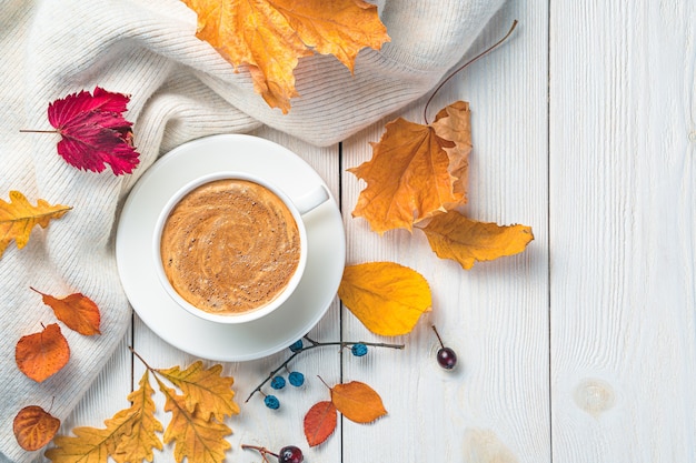 Autumn foliage cappuccino and a sweater on a light background festive autumn background