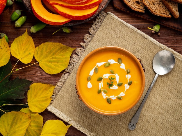 Autumn food pumpkin puree soup leaves dark brown old wooden table top view