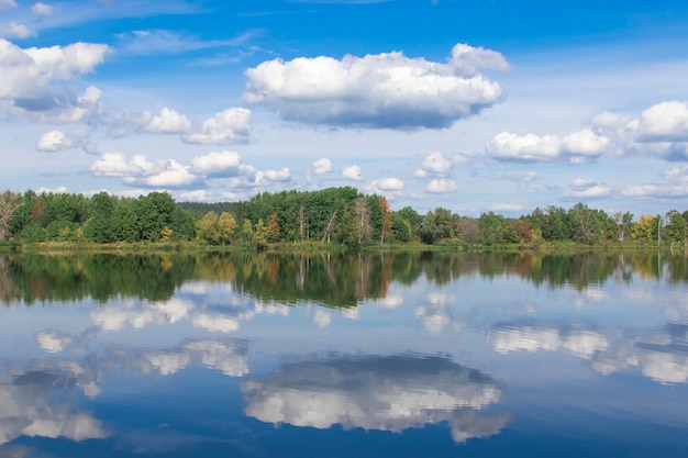 Autumn forest clouds reflected in a lake