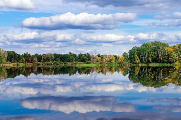 Autumn forest clouds reflected in a lake