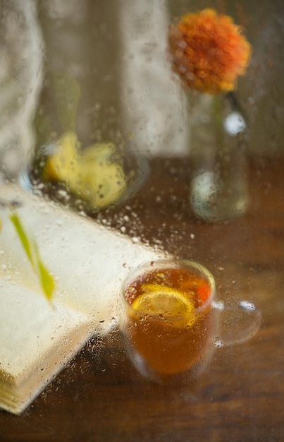 Autumn form Yellowed birch branches through a wet rainy window Book and tea with lemon Home comfort in bad weather