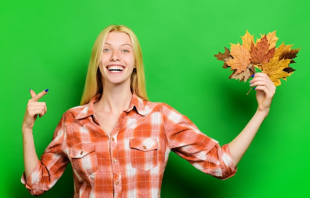 Autumn girl. Happy girl playing with leaves. Smiling woman having fun with Leaf fall. Autumnal mood.