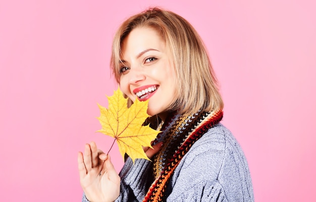 Autumn girl in warm clothes with yellow leaves beautiful woman in knitted sweater and scarf