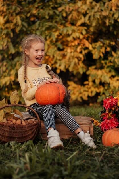 autumn girl with a pumpkin. daughter and pumpkins. autumn leaves