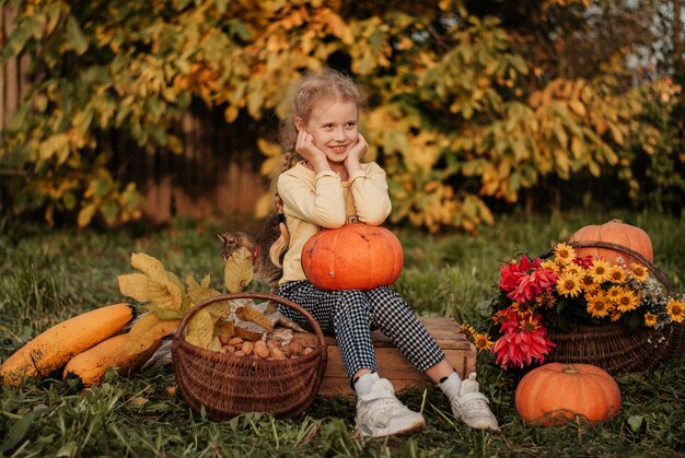 autumn girl with a pumpkin. daughter and pumpkins. autumn leaves