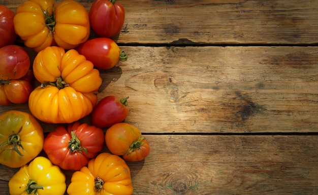 Autumn harvest food background Organic farm vegetables on wooden backdrop Fresh ripe yellow tomatoes