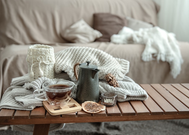 Autumn home composition with a cup of tea, a teapot and a knitted element.