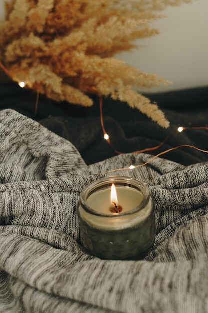 Autumn home decor with a candle and dry plant