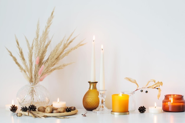 Autumn home decorations with burning candles