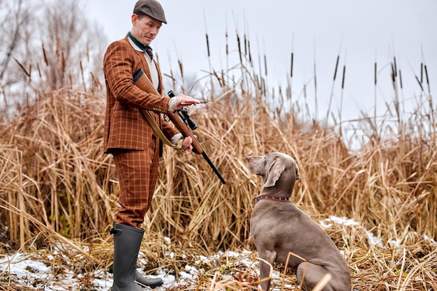 Autumn hunting season open caucasian male in brown suit hunter or poacher give commands training the...