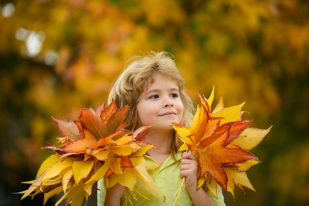 Autumn kids mood child with fall leaves over maple leaf background