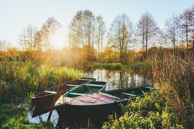 Autumn landscape on the river at sunset with boats