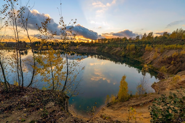 Autumn landscape with beautiful clouds over the lake at sunset. Leningrad region.