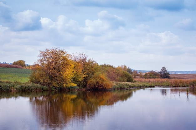 Autumn landscape with trees reflected in the river