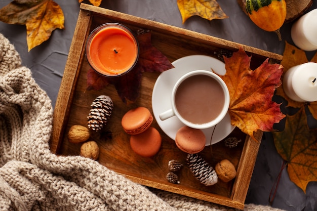 Autumn layout A cup of hot cocoa on a wooden tray with macaroons