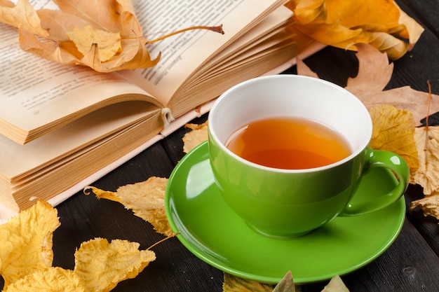 Autumn leaves, book and cup of tea