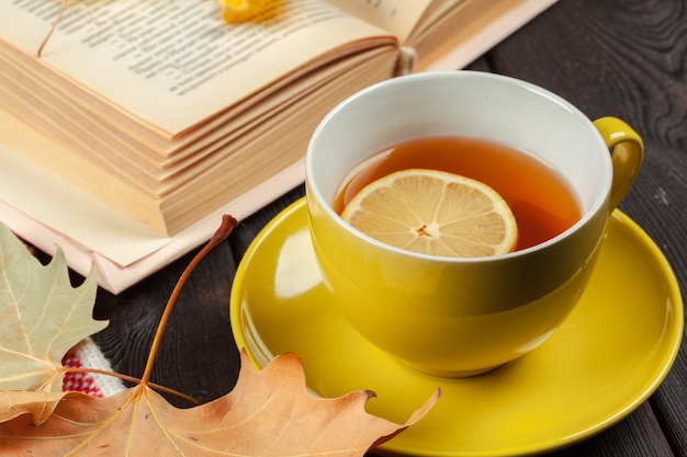 Autumn leaves, book and cup of tea