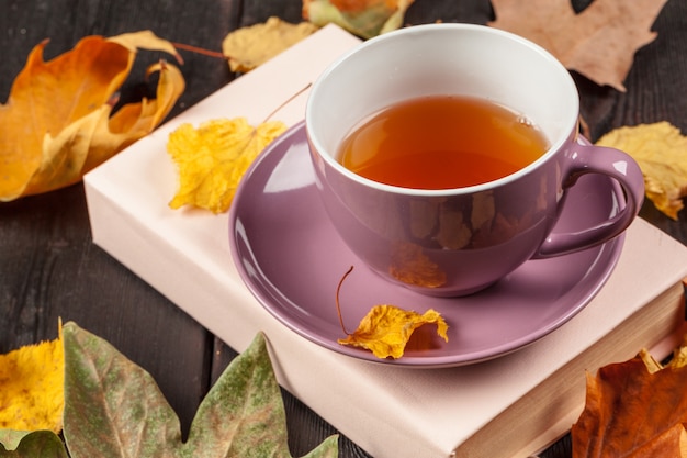 Autumn leaves, book and cup of tea