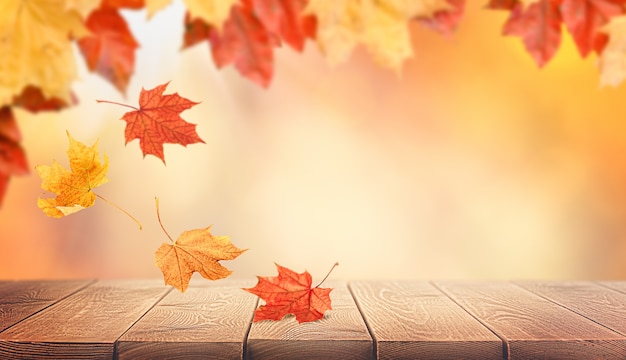 Autumn leaves falling on wooden table