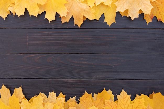 Autumn leaves frame on wooden background top view Fall Border yellow and Orange Leaves vintage wood table Copy space for text