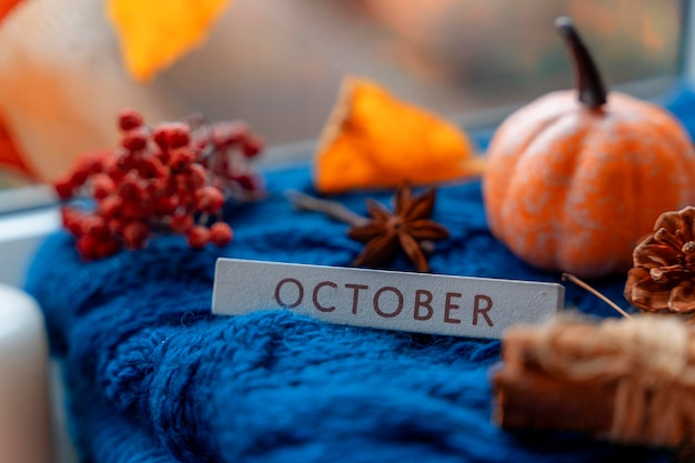 Photo autumn leaves with an blue scarf a candle a cone acornes cinnamon pumpkin autumn berry anoce